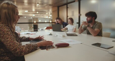 A diverse group of professionals in an office, working together on a marketing strategy. Focused on data analytic and market research for successful targeting and customer engagement.