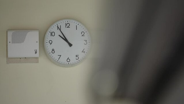 Typical school clock anchored on a wall.