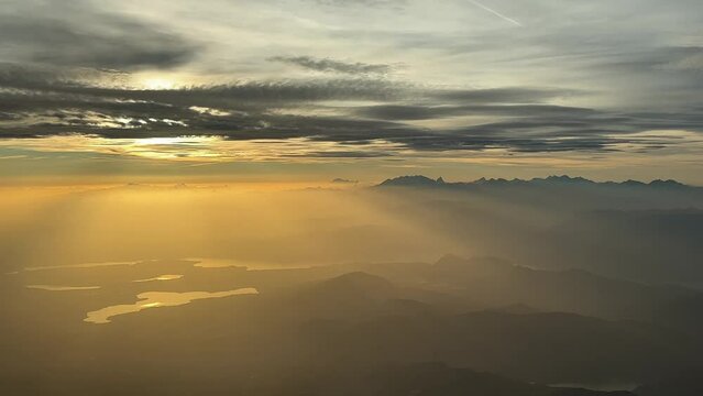 A pilot&rsquo;s perspective of the italian Alps mountains while flying northbound at 9000m high near the Lago Maggiore juste before sunset, at the golden minute.