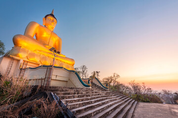 Large hilltop Golden Buddha statue at Wat Phousalao,overlooking Mekong River at sunset,Pakse,Laos.