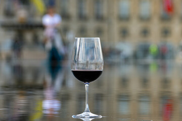 Tasting of Bordeaux blended red wine with wine city Bordeaux on background, left bank of Gironde...