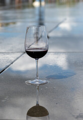 Tasting of Bordeaux blended red wine with wine city Bordeaux on background, left bank of Gironde Estuary, France. Glass of red French wine.