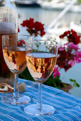 Pouring in glasses of cold rose Cote de Provence wine in yacht harbour of Port Grimaud, summer vacation on French Riviera Provence, France