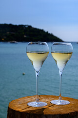 Summer time in Provence, two glasses of cold champagne cremant sparkling wine on famous Pampelonne sandy beach near Saint-Tropez in sunny day, Var department, France