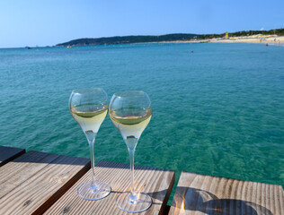 Summer time in Provence, two glasses of cold champagne cremant sparkling wine on famous Pampelonne sandy beach near Saint-Tropez in sunny day, Var department, France