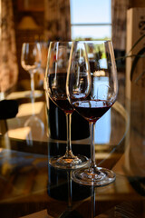 Tasting of red dry wine in Chateauneuf-du-Pape wine making village in France with green vineyards on large pebbles galets and sandstone clay soil