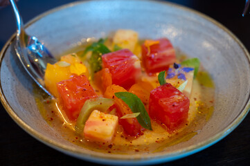Colorful healthy salad of diced assorted raw French tomatoes served on farm fresh goat’s milk burrata cheese served with vinaigrette dressing