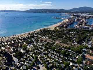 Arial view on blue water of Gulf of Saint-Tropez, sandy beach, houses in Port Grimaud, village on Mediterranean sea with yacht harbour, Provence, summer in France