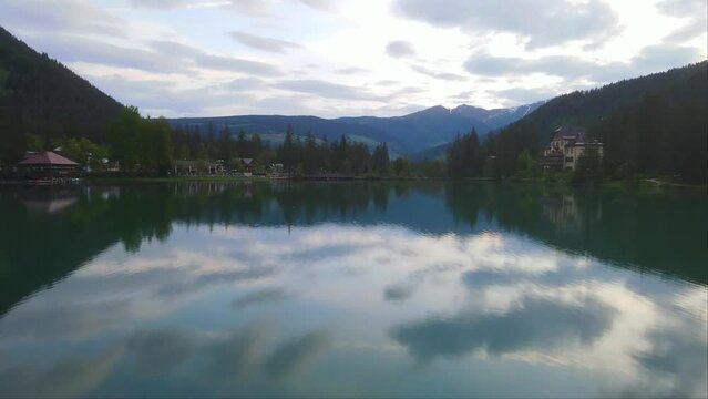 Drone forward shot of big Lake Dobbiaco and its reflection in Toblacher See, South Tyrol, Italy. Drone landscape view.