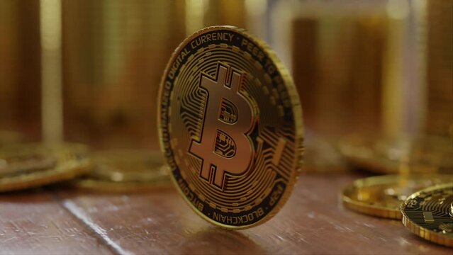 Focus on a single bitcoin spinning on a wooden table