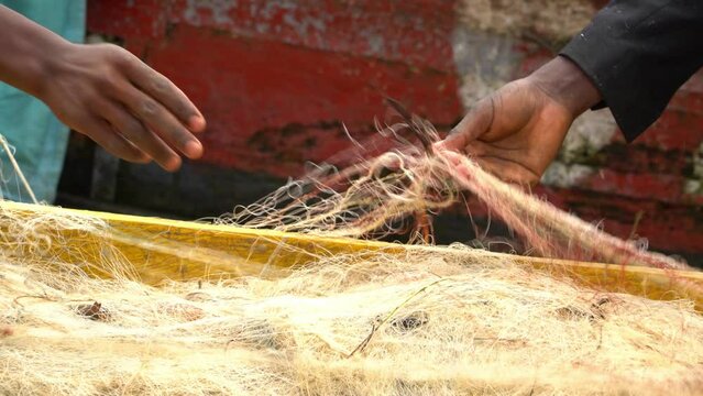 African fishermen hands work on fishing nets in Uganda, Africa