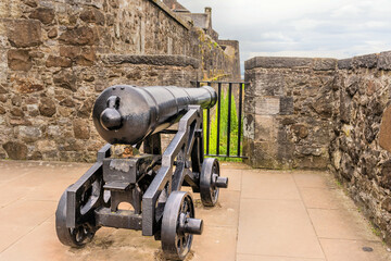 Fototapeta na wymiar Cannon mounted on metal cart on rampart of castle.