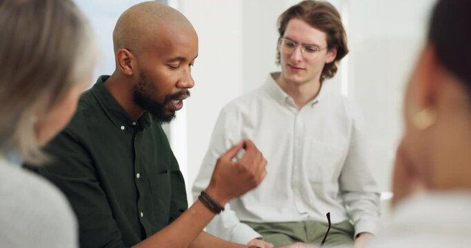 Sad man, group or therapy with empathy, support or consulting with comfort, burnout or depression. Men, crying or psychologist counselling an African person for mental health in recovery for healing
