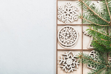 Christmas background, postcard. Christmas wooden decorations in a box and fir branches, holiday in eco style.Christmas eco-friendly decorations. Place for test.