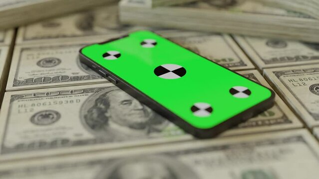 Stacks upon stacks of one hundred dollars and a phone with green screen on it