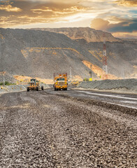 open pit diamond mine, mining grader and dust truck maintaining the gravel dirt road with access to...