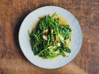 top view dish of stir-fried spinach with shitake mushroom and chili