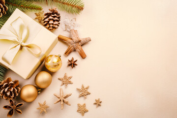 Christmas decoration composition on beige background with gift box , fir branches, pine cones, starfish,  cinnamon, top view, copy space, banner format