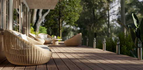 Side view of a beautiful deck with cosy round wicker armchairs and a beautiful green nature view.