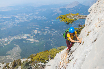 climber goes along the rocky ridge. girl climbing in the mountains. the concept of adventure and...