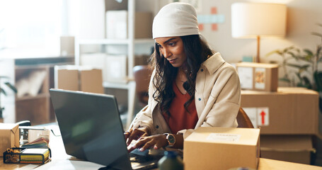Woman, laptop and typing in small business logistics for order, ecommerce or design at boutique. Female person, tailor or fashion designer on computer for inventory, storage or inspection at store
