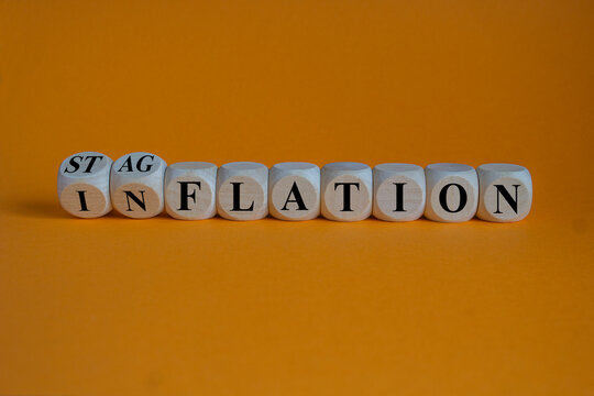 Stagflation or inflation symbol. Turned wooden cubes and changed the concept word inflation to stagflation. Beautiful orange background, copy space. Business stagflation or inflation concept.