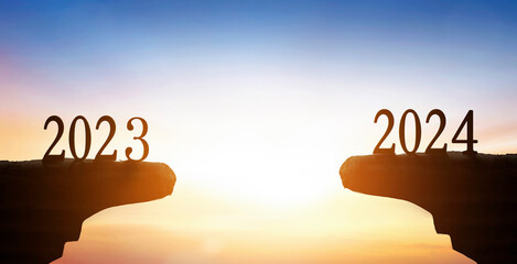 New Year 2024 and 2023 on on the mountain at sunset background - obrazy, fototapety, plakaty