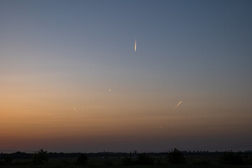 Multiple airplane jet streams in the dusk sky. Wide angle, sunset light, flat field, no people