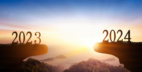 New Year 2024 and 2023 on on the mountain at sunset background