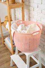 Pink plastic laundry basket in a bathroom
