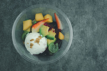 Yogurt with many fruits in a plastic cup to go. The fruit fruit such as strawberries, grapes, kiwi and mango put fresh yogurt.