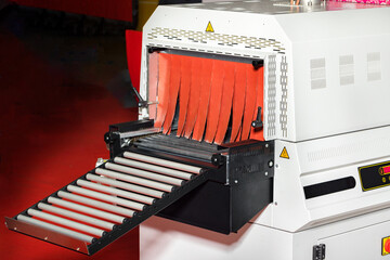 Fragment of a tunnel mini-shrinking machine for packaging food products.
