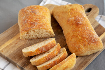Homemade Ciabatta Bread on a wooden board, side view.