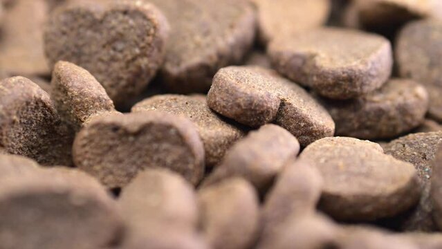 Revolving heart-emulating dog bites in a dish. Appetizing tidbits against a white setting. Showcasing owner's endearment.