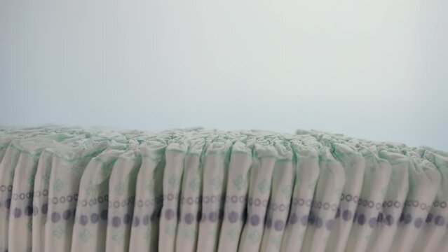 Lots of baby cotton diapers on a white background. The concept of softness, lightness and naturalness. Hypoallergenic, copy space for text. Copy space for text. Slow motion