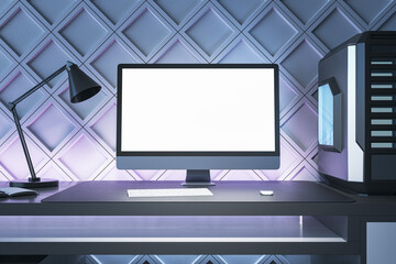 Creative gamers desktop with empty white computer screen, lamp and system unit on decorative blue wall background. Gaming concept. Mock up, 3D Rendering.