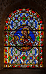 Val d'Oingt, France - 08 29 2021: Rhône Vineyard. View of the stained glass medallion of Saint Matthew in the church of Oingt, medieval building.