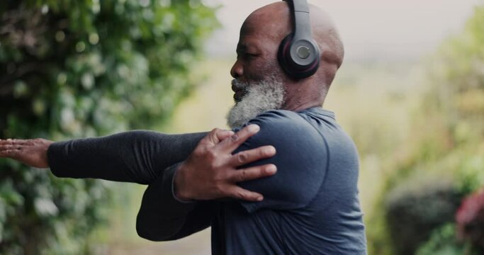 Old man, African with headphones and stretching in park, running and cardio with fitness, health and listen to music. Warm up, start run and audio streaming, podcast or radio with vitality outdoor
