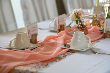 wedding decorations. Served wedding table with decorative natural flowers and. holiday details. flower arrangement, plates and candles in candlesticks, glasses