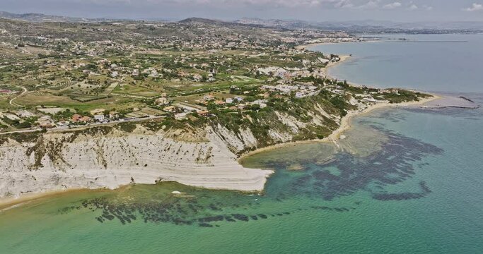 Scala dei Turchi Italy Aerial v2 cinematic fly around Stair of the Turks capturing coastal landscape of spectacular white marl sea cliff and Realmonte town views - Shot with Mavic 3 Cine - June 2023