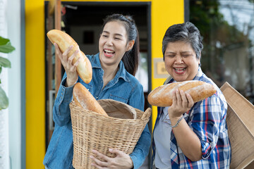 Cheerful elegant woman and mother holding a baguette basket Both of their faces were happy. They're teasing each other.
Young businesswoman and mother with traditional French toast outdoors area in fr - obrazy, fototapety, plakaty