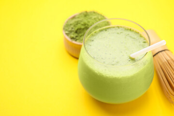 Glass of tasty matcha smoothie on yellow background, closeup. Space for text