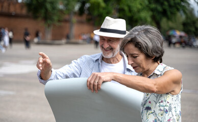 Senior Caucasian tourist couples  looking at map during summer vacation at tha pae gate, chiangmai, thailand 