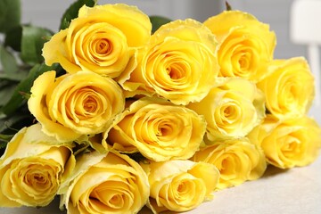 Beautiful bouquet of yellow roses on light grey table, closeup