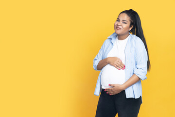 Pregnant African American woman on yellow background. - obrazy, fototapety, plakaty