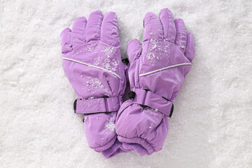 Warm stylish ski gloves on white snow