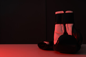 Boxing gloves are illuminated with red light