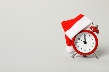A clock with a Santa hat with a New Year's decoration. - obrazy, fototapety, plakaty