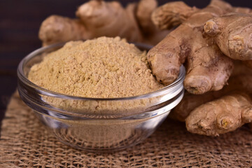 Ginger root and ginger powder in a glass bowl.Close-up.