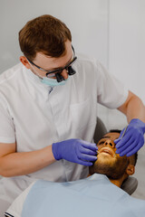 Fototapeta premium At dental clinic the patient on the dentist chair laying down he make a tooth check appointment the dentist check every teeth